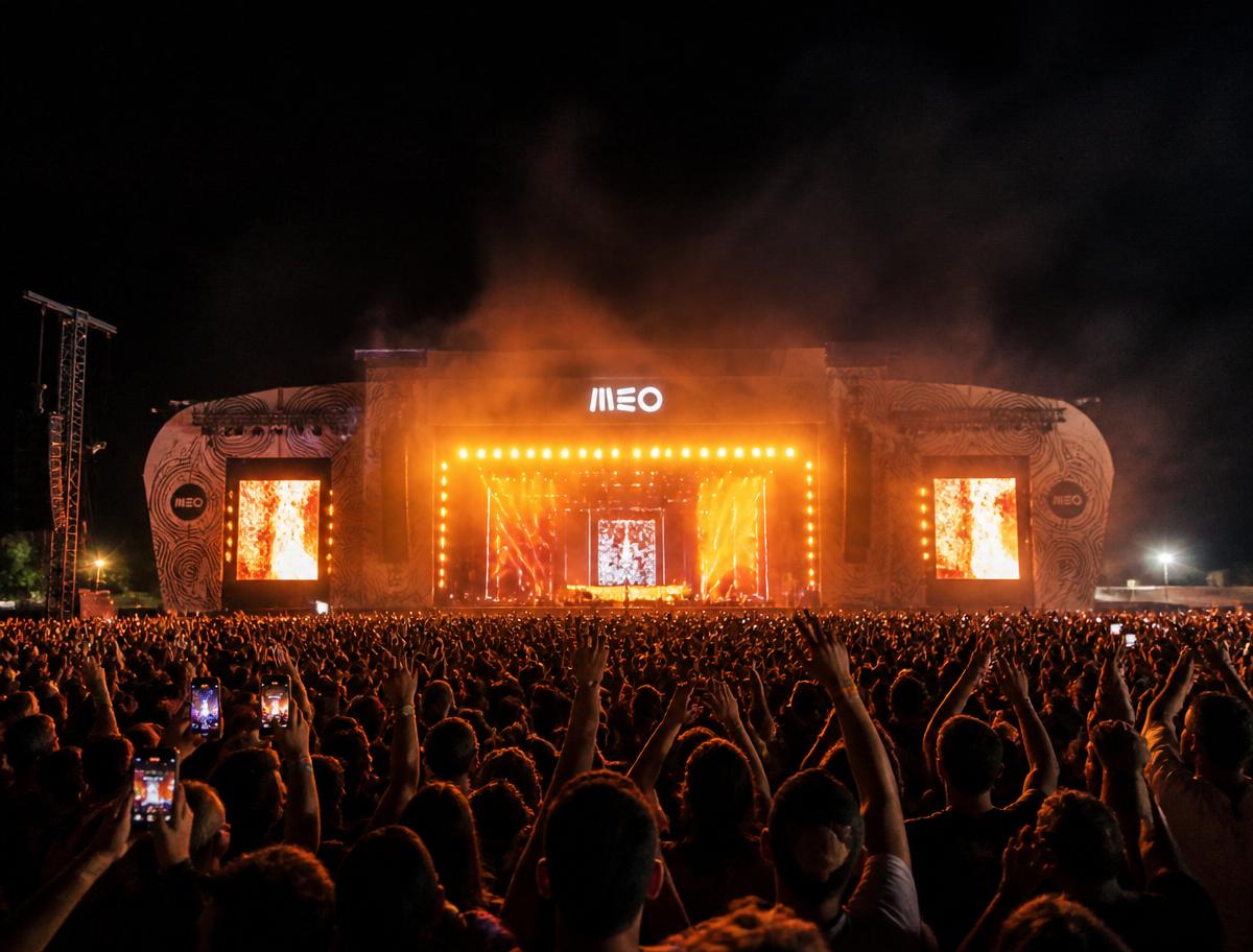 Grande palco de festival ao vivo com público e iluminação noturna